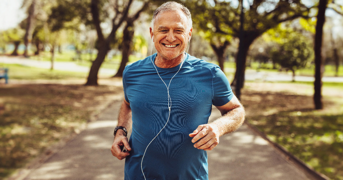 Senior man running in park smiling