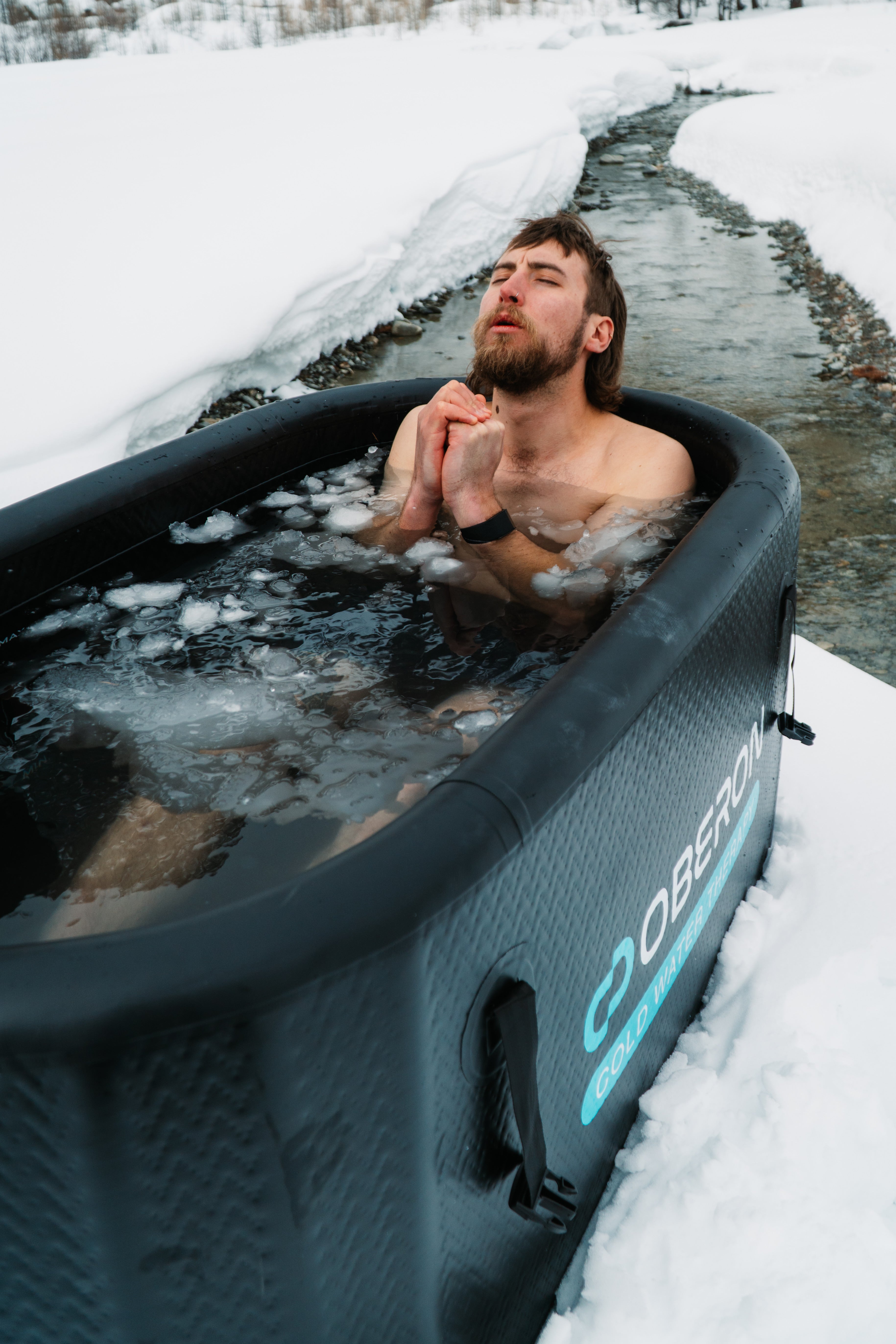 Person in a professional portable OBERON Mono Ice Bath in a snowy outdoor setting